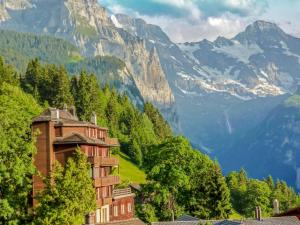 een hotel in de bergen met bergen op de achtergrond bij Apartment Schweizerhof-2 by Interhome in Wengen