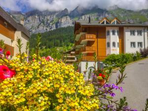 a bunch of yellow flowers in front of a building at Apartment Iris A-3 by Interhome in Leukerbad