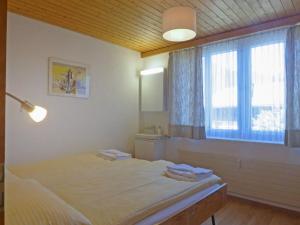 een slaapkamer met een groot bed en een raam bij Apartment Schweizerhof-2 by Interhome in Wengen