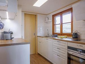 una cucina con armadietti bianchi e una finestra di Chalet Zwärgli by Interhome a Wengen