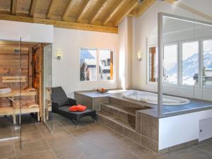 a bathroom with a tub and a glass shower at Apartment Iris A-1 by Interhome in Leukerbad