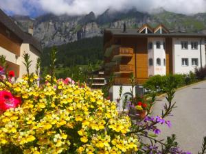 a bunch of yellow flowers in front of a building at Apartment Iris B-5 by Interhome in Leukerbad