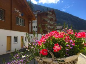a basket filled with flowers in front of a building at Apartment Iris B-5 by Interhome in Leukerbad