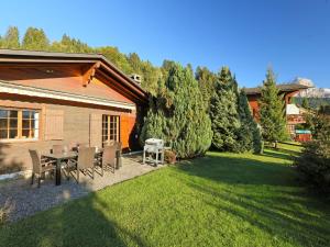 a patio with a table and chairs in a yard at Chalet Chalet Lorila by Interhome in Villars-sur-Ollon