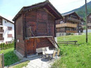 グレヘンにあるApartment Heiderösli-3 by Interhomeの小さな木造の建物(テーブル、椅子付)