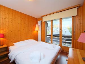 a bedroom with a white bed and a large window at Apartment Beau-Séjour 24 by Interhome in Nendaz +19 photos