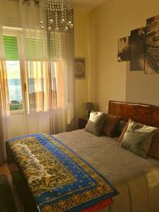 een slaapkamer met een bed en een kroonluchter bij Casa Perla in Lavagna