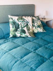 a bed with a blue comforter and a pillow at CasaAle in Anacapri