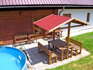 a picnic table and benches next to a swimming pool at Apartment Janová by Interhome in Janová