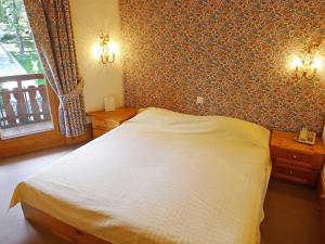 a bedroom with a white bed and a window at Apartment Le Bristol A28 by Interhome in Villars-sur-Ollon +18 photos