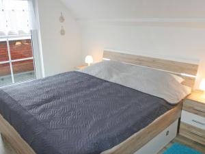 ein großes Bett in einem Zimmer mit Fenster in der Unterkunft Apartment Borkum by Interhome in Dornumersiel