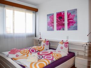 - une chambre avec un lit doté de couvertures et d'oreillers colorés dans l'établissement Apartment Residenza Cassarate Lago-1, à Lugano