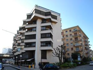 a tall building on a street with cars parked in front at Apartment Vista San Salvatore by Interhome in Lugano