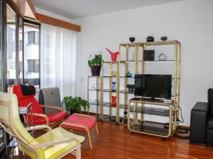 a living room with a tv and chairs at Apartment Vista San Salvatore by Interhome in Lugano +13 photos