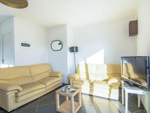 a living room with two couches and a tv at Holiday Home Kermahé by Interhome in Saint-Pierre-Quiberon
