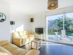 a living room with a couch and a tv at Holiday Home Kermahé by Interhome in Saint-Pierre-Quiberon
