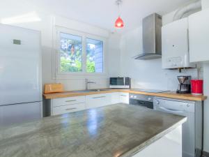 a kitchen with white cabinets and a counter top at Holiday Home Kermahé by Interhome in Saint-Pierre-Quiberon