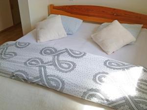 a bed with two pillows on top of it at Holiday Home Domek Joanna-2 by Interhome in Łeba