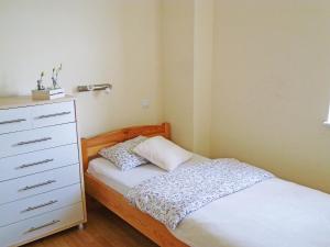 a small bedroom with a bed and a dresser at Holiday Home Domek Joanna-2 by Interhome in Łeba