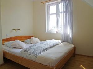 a bed in a room with a window and a bed sidx sidx sidx at Holiday Home Domek Joanna-2 by Interhome in Łeba