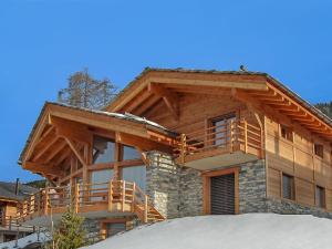 una baita di tronchi con un ponte avvolgente nella neve di Chalet Sebas by Interhome a Nendaz
