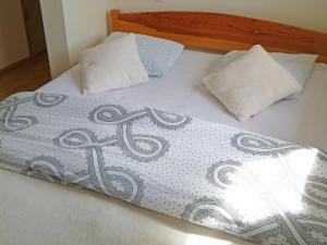 a bed with two pillows on top of it at Holiday Home Domek Joanna-3 by Interhome in Łeba
