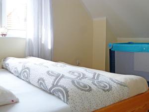 a bed with a white blanket on top of it at Holiday Home Domek Joanna-3 by Interhome in Łeba