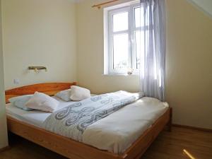 a bed in a room with a window and a bed sidx sidx sidx at Holiday Home Domek Joanna-3 by Interhome in Łeba