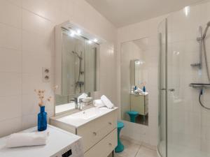 a white bathroom with a sink and a shower at Apartment La Sauvagère-1 by Interhome in Carnac-Plage