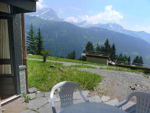 two chairs sitting on a porch with a view of a mountain at Apartment La Vire D'Aufalle 14 Inférieur by Interhome in Arveyes