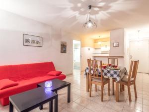 a living room with a red couch and a table at Apartment Central Parc by Interhome in Quiberon