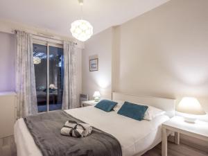 a bedroom with a large white bed with blue pillows at Apartment Central Parc by Interhome in Quiberon