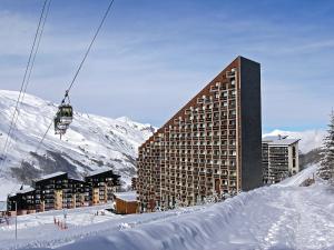 a building in the snow with a ski lift at Apartment Belleville Caron-11 by Interhome in Les Menuires