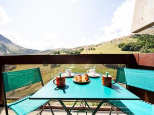 un tavolo blu con un piatto di cibo in cima a una montagna di Studio Lunik Orion-32 by Interhome a Le Corbier