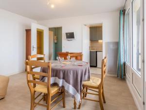 a dining room with a table and chairs and a kitchen at Apartment les Colombières by Interhome in Villers-sur-Mer