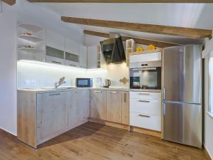 een keuken met witte kasten en een roestvrijstalen koelkast bij Apartment Majda by Interhome in Kmeti