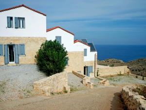 a house on a hill with the ocean in the background at Holiday Home Puntiti 3 by Interhome in Kókkinon Khoríon