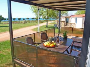 einen Tisch mit einer Obstschale auf dem Balkon in der Unterkunft Holiday Home Camping Park Umag by Interhome in Karigador