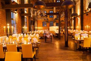 una sala da pranzo con tavoli e sedie gialle di Landhotel Beverland bei Münster a Ostbevern