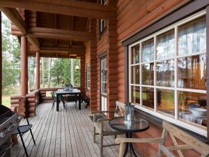 een veranda van een blokhut met tafels en ramen bij Holiday Home Raatiannokka by Interhome in Ikaalinen