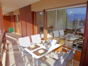 a room with a table and chairs and a large window at Apartment Monte Cristo 6 by Interhome in Crans-Montana