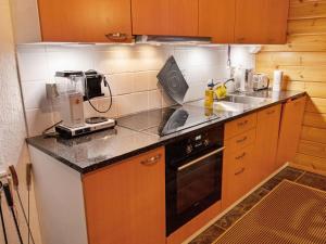 eine Küche mit Spüle und Herd oberen Backofen in der Unterkunft Holiday Home Tunturitähti by Interhome in Äkäslompolo
