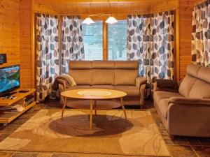 ein Wohnzimmer mit Sofa und Tisch in der Unterkunft Holiday Home Tunturitähti by Interhome in Äkäslompolo