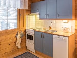 アカスロンポロにあるHoliday Home Koppelonkulma 2 by Interhomeのキッチン(青いキャビネット、シンク、コンロ付)