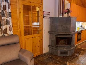 ein Wohnzimmer mit einem Holzofen in der Küche in der Unterkunft Holiday Home Tunturitähti by Interhome in Äkäslompolo