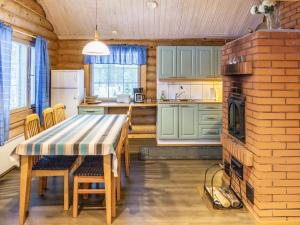 a kitchen and dining room with a table and a fireplace at Holiday Home Hanhela by Interhome in Äkäslompolo