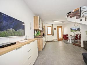 een keuken met witte kasten en een grote tv aan de muur bij Apartment Jenewein by Interhome in Fliess
