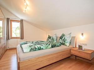 Schlafzimmer mit einem Bett mit blauen und grünen Kissen in der Unterkunft Apartment Jenewein by Interhome in Fliess