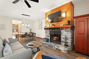 a living room with a couch and a fireplace at Les Eaux 225-1 by Escapades Tremblant in Mont-Tremblant