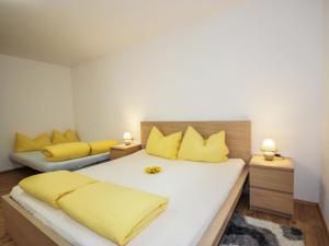 - une chambre avec 2 lits et des oreillers jaunes dans l'établissement Apartment Matilda by Interhome, à Ried im Oberinntal